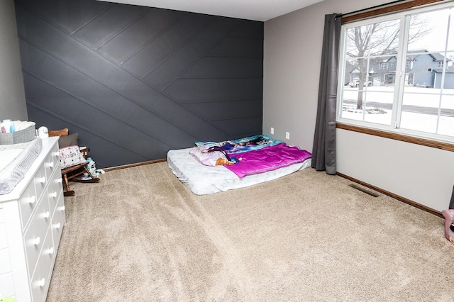 bedroom featuring wood walls and carpet