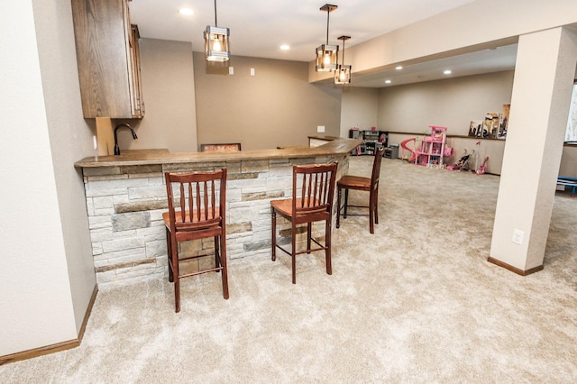 bar featuring light colored carpet, sink, and hanging light fixtures