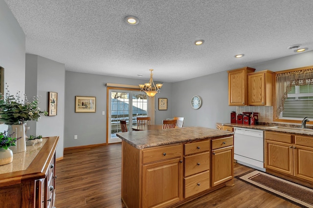 kitchen with sink, hanging light fixtures, white dishwasher, dark hardwood / wood-style flooring, and a kitchen island