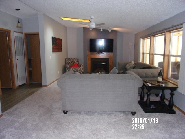 living room with ceiling fan, carpet floors, a textured ceiling, and vaulted ceiling