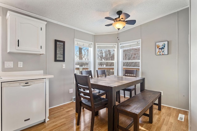 dining space featuring crown molding, ceiling fan, light hardwood / wood-style flooring, and a textured ceiling