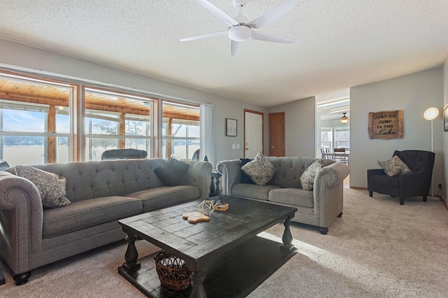 carpeted living room with a textured ceiling, plenty of natural light, and ceiling fan