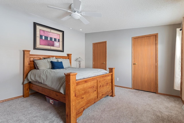 bedroom featuring ceiling fan, light colored carpet, and a textured ceiling