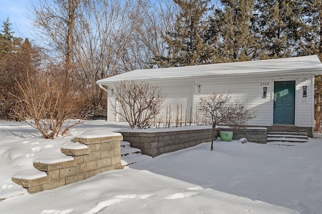 snow covered patio featuring a garage