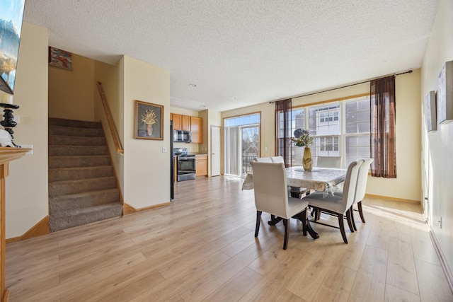 dining space featuring a textured ceiling and light hardwood / wood-style floors