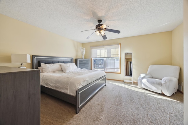 carpeted bedroom featuring ceiling fan and a textured ceiling