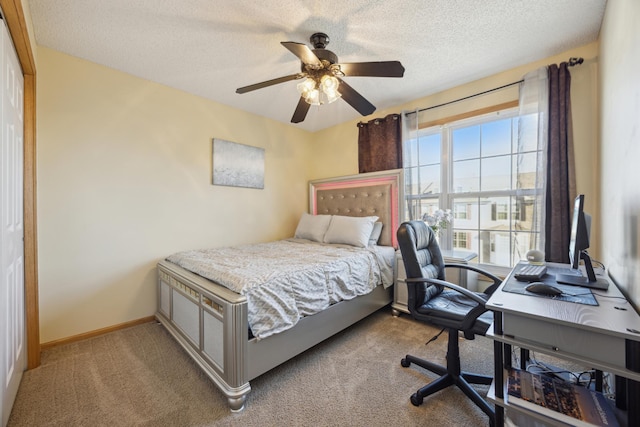 bedroom with ceiling fan, light carpet, and a textured ceiling