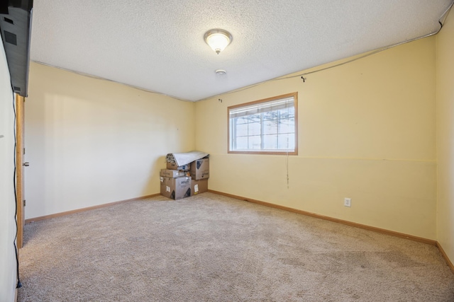 empty room with a textured ceiling and carpet flooring