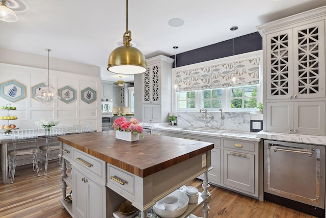 20100 Lakeview Ave, Deephaven, MN 55331 - kitchen featuring butcher block countertops, dishwasher, double oven, light wood-style flooring, and pendant lighting