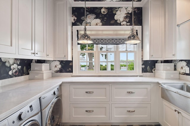 20100 Lakeview Ave, Deephaven, MN 55331 - kitchen with washing machine and clothes dryer, white cabinets, wallpapered walls, light countertops, and decorative light fixtures