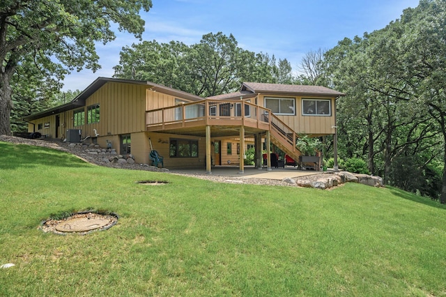 rear view of property with a patio, central AC unit, a lawn, and a wooden deck