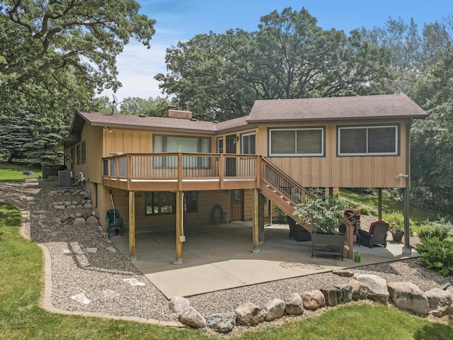 rear view of house featuring a shingled roof, central air condition unit, stairs, a deck, and a patio area