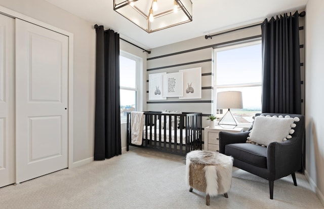 bedroom featuring a nursery area and light colored carpet