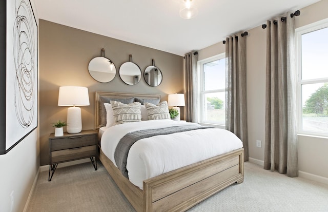 bedroom with light colored carpet and multiple windows