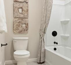 bathroom featuring toilet and shower / bath combination