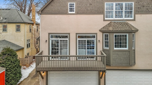 rear view of property featuring a garage and a balcony