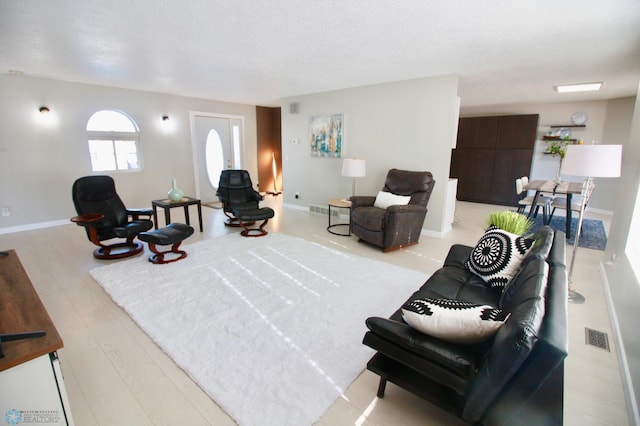 living room with light hardwood / wood-style flooring and a textured ceiling