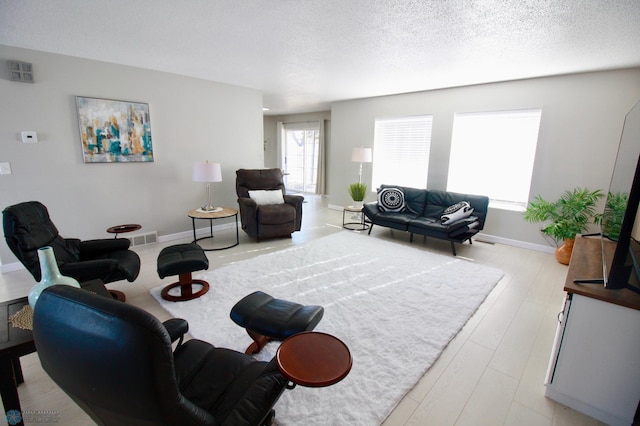 living room featuring light hardwood / wood-style flooring and a textured ceiling