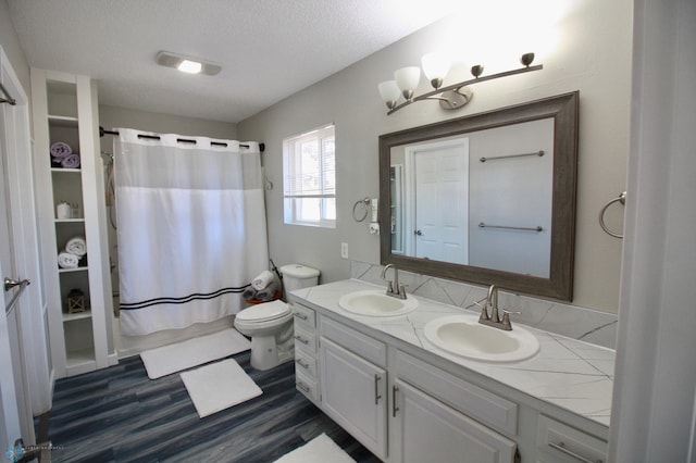 full bathroom with hardwood / wood-style flooring, vanity, toilet, a textured ceiling, and shower / bath combo with shower curtain