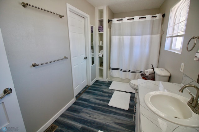 bathroom featuring vanity, toilet, hardwood / wood-style floors, and a textured ceiling