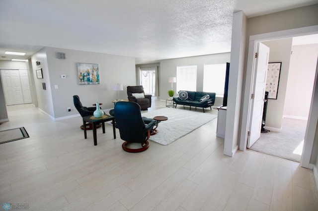 living room with light hardwood / wood-style floors and a textured ceiling