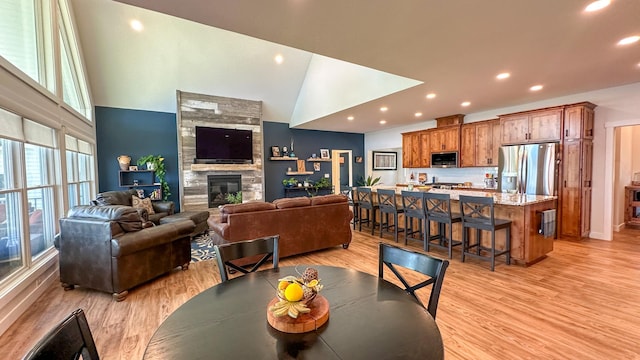 dining area featuring high vaulted ceiling and light hardwood / wood-style floors