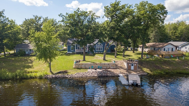 dock area with a lawn and a water view