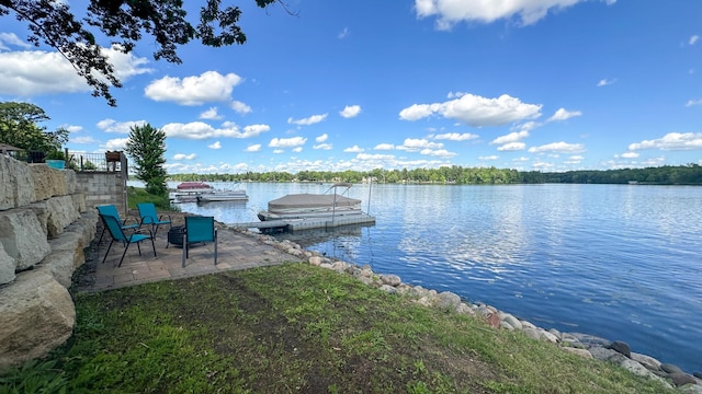 view of dock with a patio and a water view