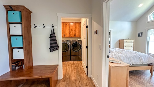 laundry area featuring cabinets, independent washer and dryer, and light hardwood / wood-style flooring