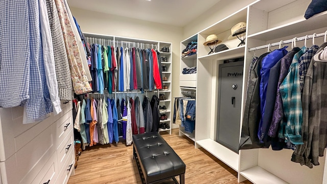 walk in closet with light hardwood / wood-style flooring