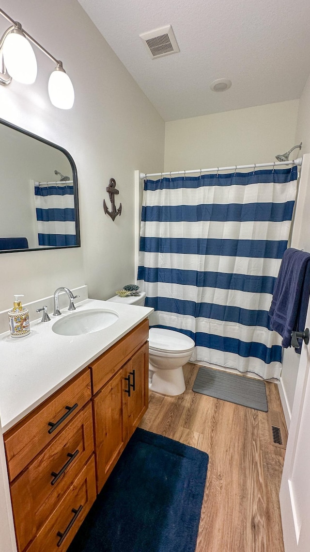 bathroom featuring hardwood / wood-style flooring, vanity, toilet, and a shower with curtain