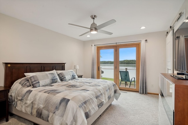 bedroom with a barn door, light colored carpet, access to exterior, and ceiling fan