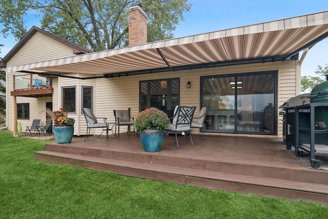 back of house featuring a wooden deck and a lawn