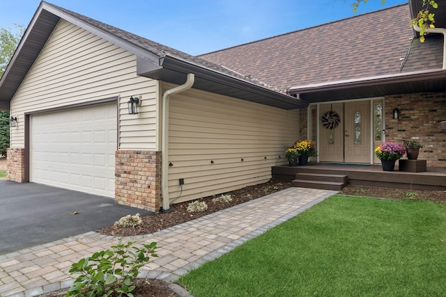 single story home featuring a garage, covered porch, and a front lawn