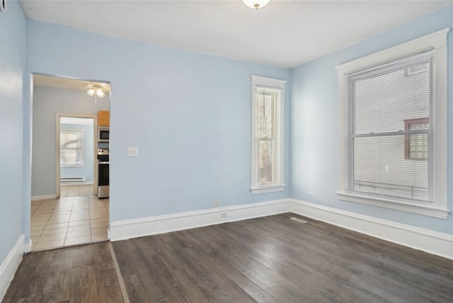 spare room with wood-type flooring and baseboard heating