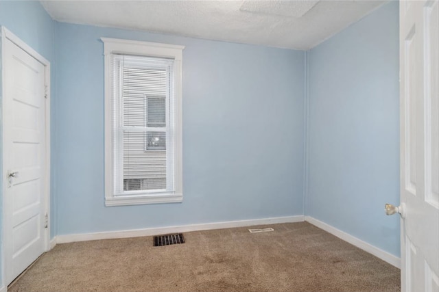 spare room with light carpet and a textured ceiling