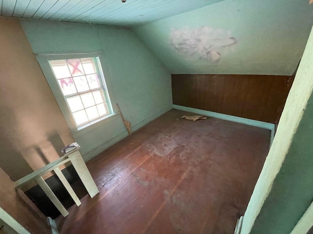 additional living space with dark hardwood / wood-style floors and vaulted ceiling