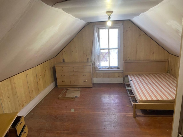 additional living space with lofted ceiling, dark wood-type flooring, and wooden walls