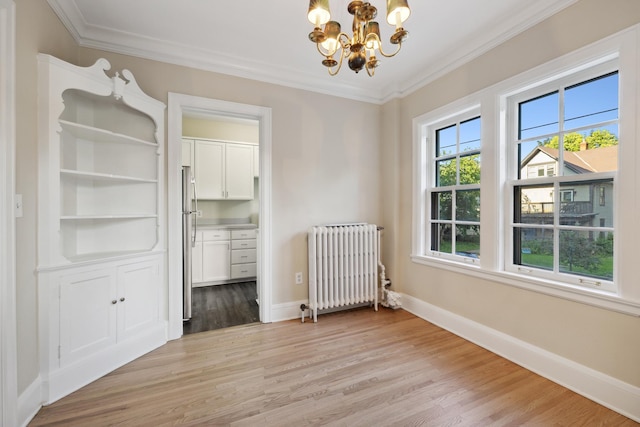 interior space featuring an inviting chandelier, ornamental molding, radiator, and light wood-type flooring