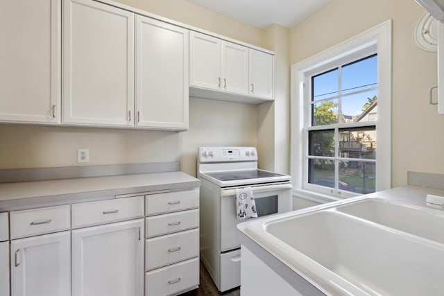 kitchen featuring white range with electric cooktop and white cabinets