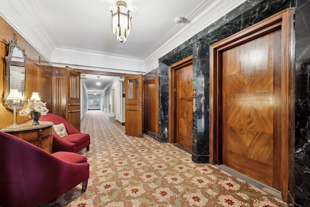 hall with ornamental molding, light carpet, and a notable chandelier