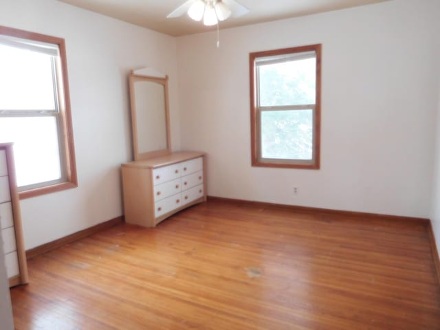 unfurnished bedroom with multiple windows and light hardwood / wood-style flooring