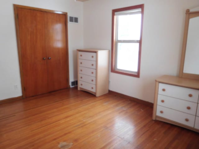 unfurnished bedroom featuring light wood-type flooring and a closet