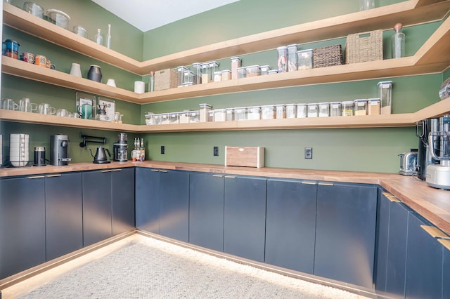 interior space featuring butcher block counters and blue cabinetry