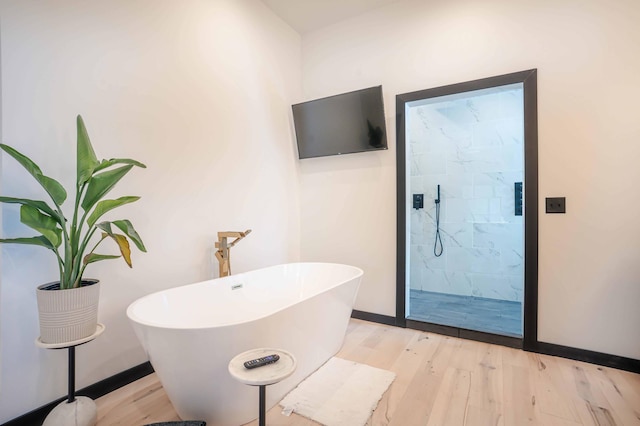 bathroom featuring wood-type flooring and shower with separate bathtub