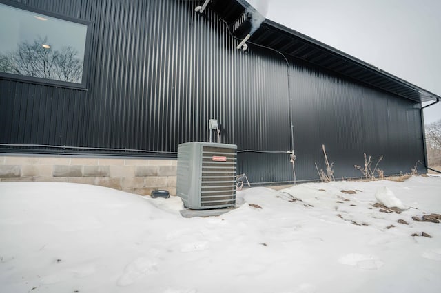 view of snowy exterior with cooling unit