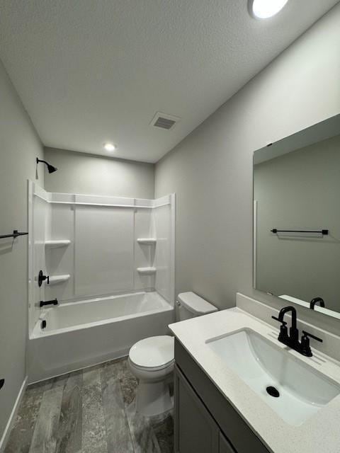 full bathroom featuring toilet, a textured ceiling, shower / bathtub combination, vanity, and hardwood / wood-style flooring