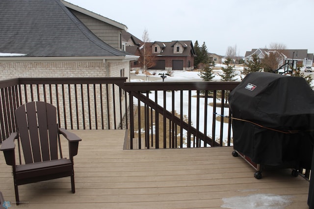 snow covered deck with a grill