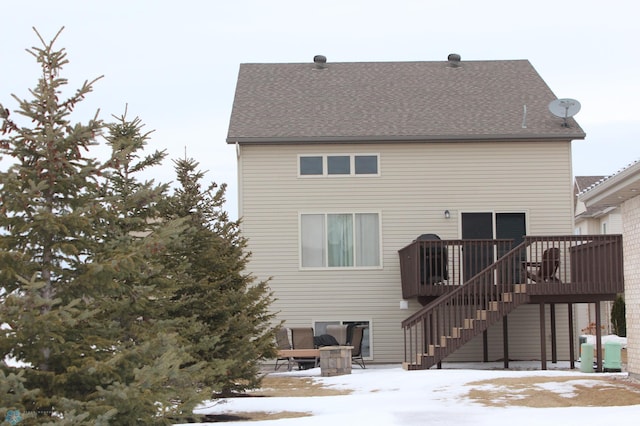 snow covered house featuring a wooden deck and central AC unit