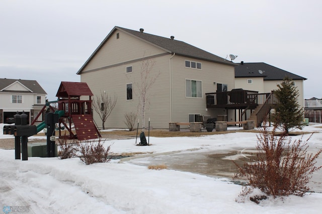 snow covered property with a playground